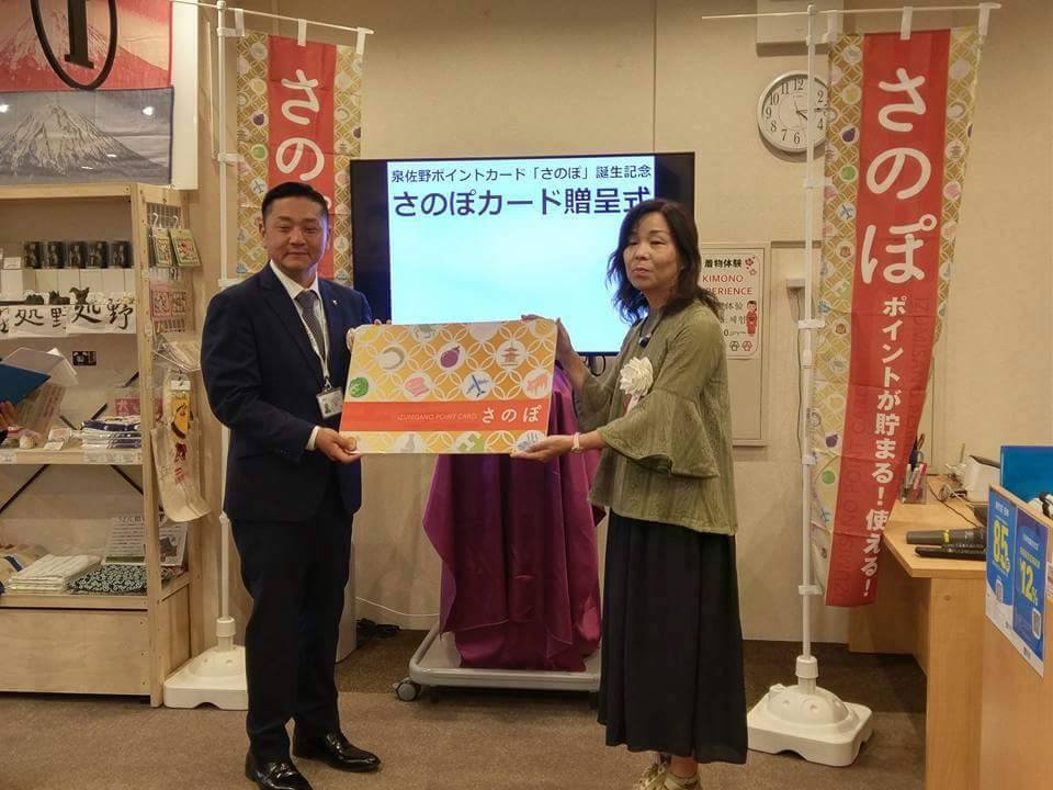 千代松市長から北谷会長へ泉佐野地域ポイント「さのぽカード」を進呈する様子